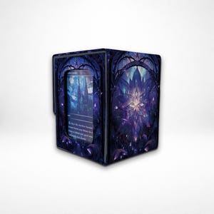 May include: A rectangular deck box for trading cards featuring a dark blue and purple stained glass aesthetic. The front panel displays a central floral pattern with intricate gothic-style arches and a clear window showing a card inside.