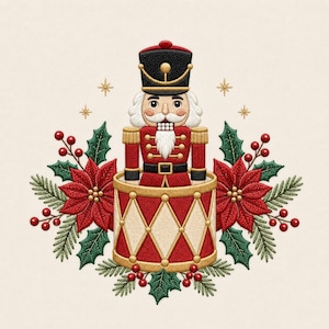 May include: An embroidered design featuring a nutcracker in a red and gold uniform standing inside a red and cream drum. The nutcracker is surrounded by red poinsettia flowers, green holly leaves, pine needles, and small gold stars.