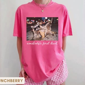 crunchberry funny aunt shirt with raccoon drinking iced coffee, somebody’s feral aunt graphic tee, cute pregnancy reveal gift for cool auntie