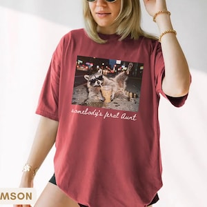 crimson funny aunt shirt with raccoon meme design, promoted to aunt announcement gift, bold and playful graphic tee