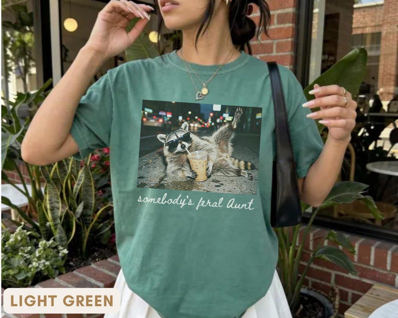 light green raccoon meme shirt for aunt, funny somebody’s feral aunt tee with iced coffee design, unique gift for new aunt