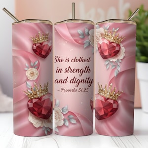 May include: A pink tumbler with a gold straw, featuring a repeating design of a jeweled heart with a gold crown, white roses, and the text "She is clothed in strength and dignity - Proverbs 31:25".