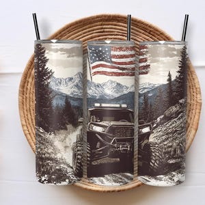 May include: Three stainless steel tumblers with black straws, each featuring a different scene. One displays an American flag, another a mountain landscape, and the third a rugged off-road vehicle. The design is printed on the tumblers.