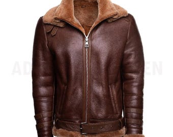 May include: A dark brown leather jacket with a tan shearling lining and collar. The jacket features a silver front zipper, a buckled waist belt, and three horizontal straps on each sleeve cuff, all lined with soft tan fur trim.