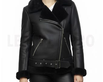 May include: Black leather jacket with a shearling collar and cuffs. The jacket features a diagonal zipper closure, a belted waist, and multiple zippered pockets. The style is a classic aviator design.
