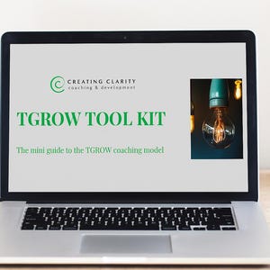 Könnte beinhalten: Ein Laptop zeigt eine Präsentation mit dem Titel "TGROW TOOL KIT" mit dem Text "The mini guide to the TGROW coaching model." Der Bildschirm zeigt auch das Logo von "Creating Clarity coaching & development" und ein Glühbirnenbild.