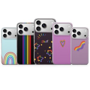 Könnte beinhalten: Fünf Smartphone-Hüllen mit verschiedenen Designs: eine hellblaue Hülle mit Regenbogenbogen, eine schwarze Hülle mit vertikalen Regenbogenstreifen, eine schwarze Hülle mit bunten Sternen und dem Wort Pride, eine rosa Hülle mit Herz und eine lila Hülle.