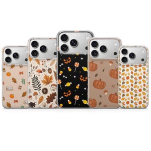 May include: Five phone cases with autumn-themed designs. The cases feature patterns of pumpkins, leaves, mushrooms, and Halloween candy. The cases are in shades of orange, brown, and black, perfect for fall.