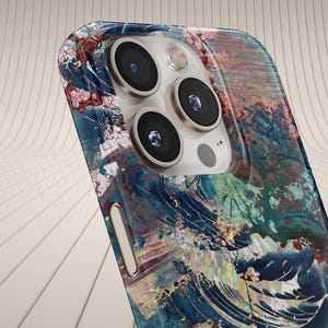 May include: A smartphone case featuring a colorful, artistic design with blue, red, and green hues. The case has a glossy finish and a multi-lens camera system. The design resembles a wave pattern.
