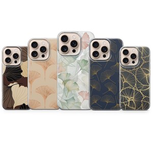May include: A collection of five phone cases with various botanical designs. The cases feature patterns of ginkgo leaves in shades of brown, beige, navy, and gold, as well as a watercolor design with green and pink leaves. The cases have clear edges.