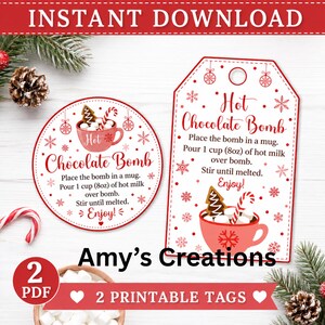 May include: Two printable tags for hot chocolate bombs featuring red text and graphics of a mug with marshmallows, a candy cane, and a gingerbread cookie. The text reads Hot Chocolate Bomb, instructions for use, and Enjoy, surrounded by snowflakes.