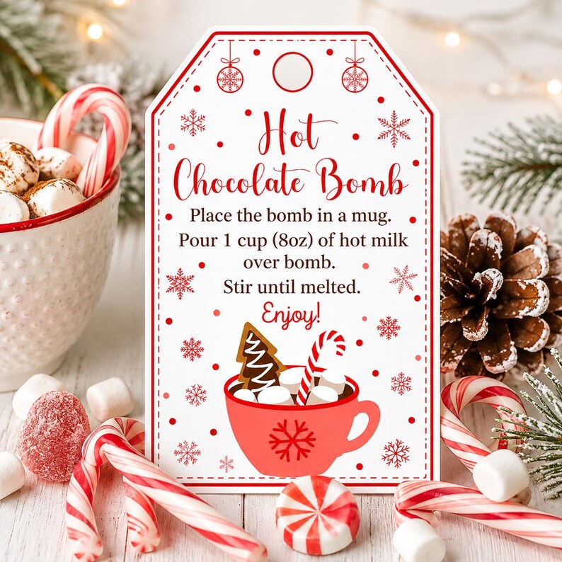 May include: A white rectangular gift tag with red borders and snowflake accents. The text reads: Hot Chocolate Bomb. Place the bomb in a mug. Pour 1 cup (8oz) of hot milk over bomb. Stir until melted. Enjoy! Features a red mug graphic.