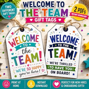 May include: Two white rectangular gift tags with twine loops. The left tag reads Welcome to the Team! We're so happy you're here! in colourful text. The right tag reads Welcome to the Team! We're thrilled to have you on board! in blue and green.