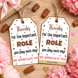 May include: Two white rectangular gift tags with brown twine loops, featuring brown and gold polka dots. The text reads: Thanks for the important ROLE you play each day! WE APPRECIATE YOU! One tag includes the additional text: Love, Amy.