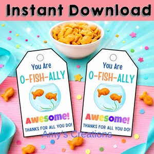 Könnte beinhalten: Zwei weiße rechteckige Geschenkanhänger mit einem Loch oben, mit einer blauen Fischglas-Illustration mit zwei orangefarbenen Fischen und dem Text "You Are O-FISH-ALLY AWESOME! THANKS FOR ALL YOU DO!" über einer Schale mit orangefarbenen Fisch-Crackern.