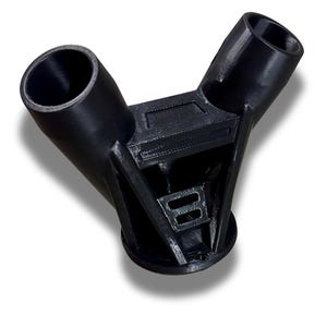 Puede incluir: Un conector de pl&aacute;stico negro en forma de Y con dos aberturas cil&iacute;ndricas anguladas y una estructura de soporte central. El conector tiene una superficie texturizada y est&aacute; dise&ntilde;ado para unir tubos o tuber&iacute;as. La base es circular.