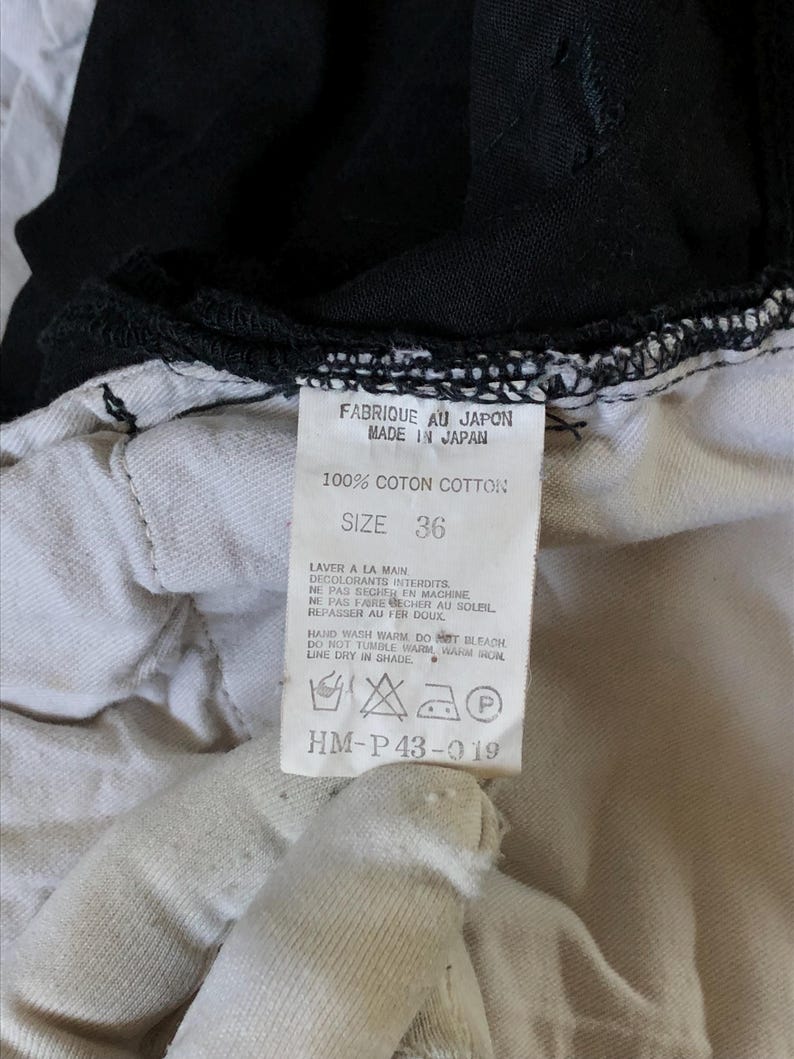 Puede incluir: Primer plano de una etiqueta de prenda. La etiqueta dice "FABRIQUE AU JAPON MADE IN JAPAN" y "100% COTON COTTON". La talla es 36. Tambi&eacute;n se imprimen instrucciones de lavado. La etiqueta es blanca con texto negro.