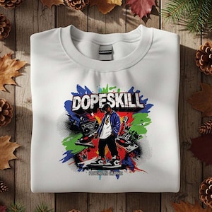 May include: White sweatshirt with a colorful graphic design. The design features the word "DOPESKILL" in blue and black, along with an illustration of a person wearing a blue jacket, a boombox, and the text "PICTURE ME GRAPHIC".