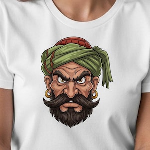May include: White t-shirt featuring a detailed illustration of a stern-faced man with a dark mustache and beard. He wears a green turban with a red cap and gold hoop earrings. The graphic has a cartoon style.