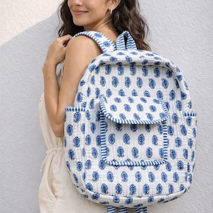 Può includere: Zaino bianco con motivo paisley blu. Lo zaino ha una chiusura con patta, tasche laterali e dettagli a righe. Realizzato in tessuto trapuntato, con spallacci regolabili.