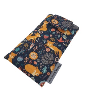 Könnte beinhalten: Eine dunkelblaue Handyhülle mit einem Blumenmuster mit orangefarbenen Füchsen und bunten Blumen. Die Hülle hat einen Klappverschluss und der Text "Konsum & Lifestyle" ist unten rechts aufgedruckt.