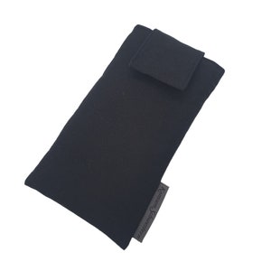 Könnte beinhalten: Schwarze Handyhülle aus Stoff mit Klappenverschluss. Die Hülle hat ein kleines Etikett mit dem Text "Korinna Spaces.com" in der unteren rechten Ecke.