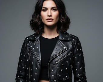 May include: A black leather jacket with silver star studs. The jacket has a classic biker style with a notched collar, asymmetrical zipper, and multiple pockets. The model is wearing a black top.