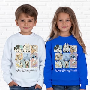 May include: Two children wearing sweatshirts. One is white, the other is blue. Both sweatshirts feature a grid of Disney character illustrations and the text "Walt Disney World" in black script.