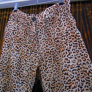 May include: A pair of brown and white leopard print pants. The pants are made of a soft, silky fabric and have a relaxed fit.