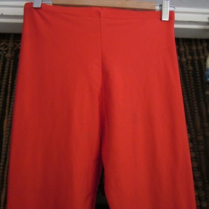 May include: A pair of bright red leggings made of a stretchy fabric.