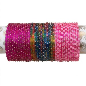 May include: A collection of thin bangles arranged in a row, featuring a variety of vibrant colours including magenta, orange, blue, green, and light pink. Each bangle is decorated with a repeating leaf pattern and small embedded clear stones.