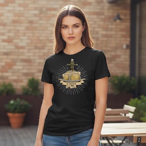 May include: Black t-shirt with a graphic of the Holy Hand Grenade of Antioch. The design includes a stylized grenade with a cross, radiating lines, and a banner with text. The shirt is a crew neck. The text reads "The Holy Hand Grenade of Antioch."