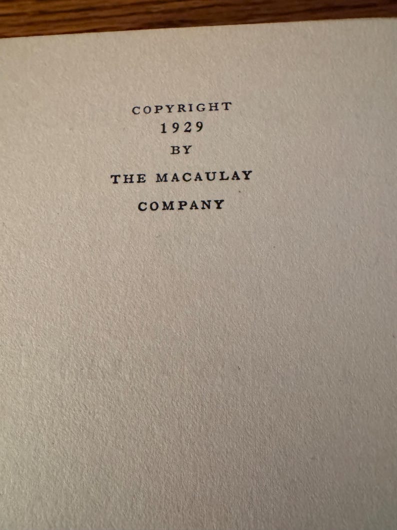 K&ouml;nnte beinhalten: Nahaufnahme einer Seite mit Text. Der Text lautet "COPYRIGHT 1929 BY THE MACAULAY COMPANY" in einer klassischen Serifenschrift. Das Papier hat ein strukturiertes, cremefarbenes Aussehen, was auf ein gealtertes Buch oder Dokument hindeutet.