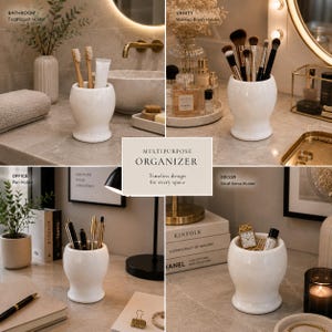 May include: A white ceramic multipurpose organiser with a smooth, rounded, hourglass-like shape. The container features a wide base and a flared rim, designed to hold various items such as toothbrushes, makeup brushes, pens, or small decor accessories.