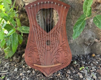 Lira de madera de palisandro con 10 cuerdas metálicas. Incluye funda y llave.