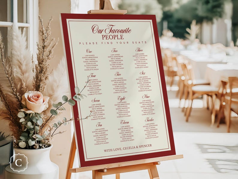Puede incluir: Un plano de asientos de boda en un caballete. El letrero con marco burdeos tiene un fondo color crema con nombres enumerados bajo los n&uacute;meros del uno al doce. El texto en la parte superior dice "Our Favourite People". El texto inferior dice "With Love, Cecelia & Spencer."