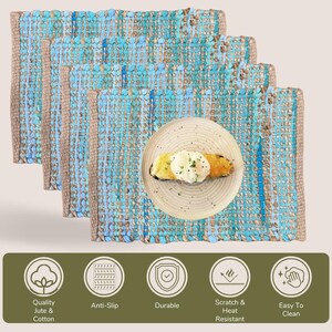 May include: Four woven placemats with a blue and tan color scheme. Each placemat has a rectangular shape with a textured surface. A plate with food is on top of one of the placemats. The image also includes icons with text that reads: Quality Jute & Cotton, Anti-Slip, Durable, Scratch & Heat Resistant, and Easy To Clean.