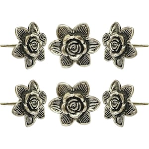 May include: Six silver-toned flower-shaped cabinet knobs. Each knob features a detailed rose center surrounded by six petals. The knobs are designed with a stem for easy installation on drawers or cabinets. The floral design adds a decorative touch.
