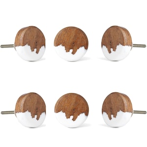May include: Six round wooden cabinet knobs with a white base and a brown wood top. Each knob has a metal screw for installation. The knobs are arranged in two rows of three, showcasing their design and potential use in home decor.