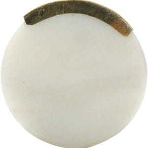 May include: A round, white marble cabinet knob with a curved, brass-colored metal accent. The knob is smooth and polished, with a slight variation in the white color. The metal accent is slightly tarnished.