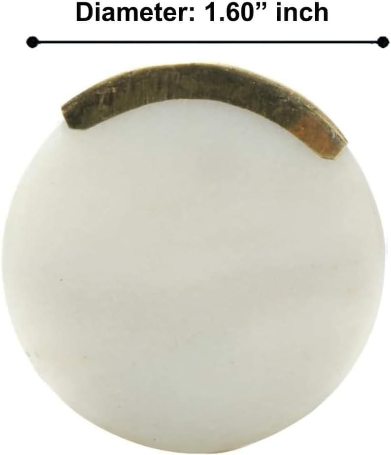 May include: A round, off-white object with a diameter of 1.60 inches. A curved, brass-colored metal piece is affixed to the top. The object appears to be a decorative element or component, possibly for furniture or crafts.