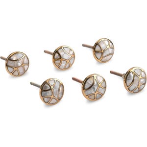 May include: Six decorative cabinet knobs with a gold-colored rim and a white, mosaic-like design. The knobs have a small, silver-colored post for mounting. The knobs are round and appear to be made of metal and mother of pearl.