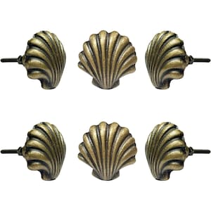 Può includere: Sei pomelli per armadi a forma di conchiglia in ottone antico. Ogni pomello presenta un design a conchiglia dettagliato e scanalato con finitura in ottone scuro. I pomelli sono progettati per una facile installazione su cassetti o armadi.
