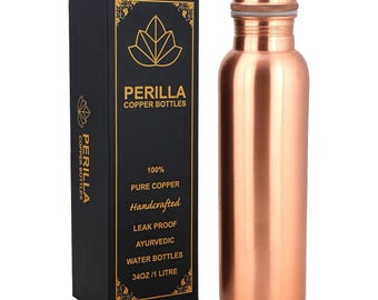 May include: A copper water bottle and its black box are displayed. The bottle is cylindrical with a copper lid. The box has the brand name "PERILLA COPPER BOTTLES" and text indicating it is 100% pure copper, handcrafted, leak proof, and Ayurvedic. The bottle holds 34oz or 1 liter.