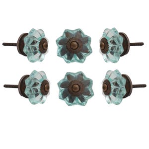 May include: Six aqua-colored glass flower-shaped cabinet knobs with bronze-colored metal bases and screws. The knobs are arranged in two rows of three, showcasing their decorative design and hardware.