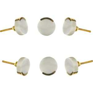 May include: Six white cabinet knobs with gold-colored accents. The knobs have a round, marble-like appearance and are attached to gold-colored screws. The knobs are arranged in a symmetrical pattern against a white background.