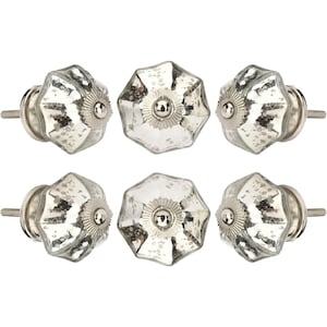 Könnte beinhalten: Sechs silberfarbene Schrankknöpfe mit einer Oberfläche aus Spiegelglas. Jeder Knopf hat eine facettierte, blütenartige Form mit einem zentralen, kreisförmigen Akzent. Die Knöpfe sind in zwei Reihen zu je drei Stück angeordnet.