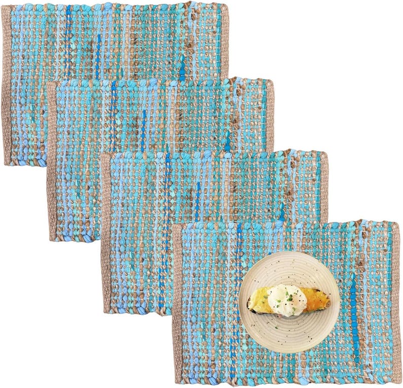 May include: A set of four rectangular placemats with a woven design in shades of blue and tan. One placemat has a plate with a piece of toast topped with an egg. The placemats have a textured appearance and a neutral border.