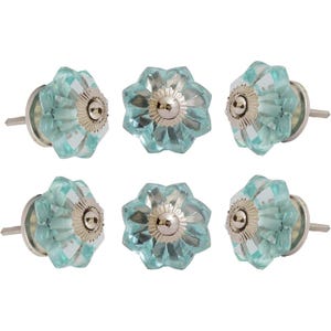 Könnte beinhalten: Sechs türkisblaue Glasschrankknöpfe mit Blumendesign. Jeder Knopf hat eine facettierte, blütenblattartige Form mit silberfarbener Metallbasis und Schraube. Die Knöpfe sind in zwei Dreierreihen angeordnet.