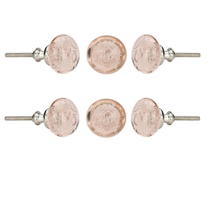 May include: Six decorative cabinet knobs. Each knob features a clear, bubble-like design with a pinkish hue. The knobs have a silver-colored metal base and screw for easy installation. Ideal for adding a touch of elegance to furniture.